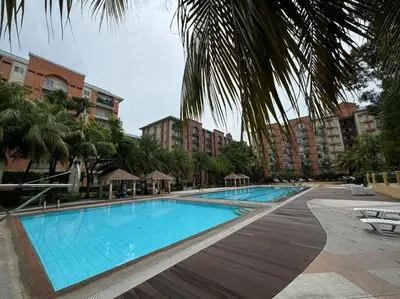 a large swimming pool with palm trees and buildings at Kalizta Suites in Manila