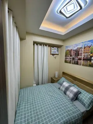 a bedroom with a bed with a blue comforter at Kalizta Suites in Manila