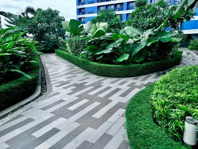 a walkway in a garden with plants and a building at Ikigai Charlie Makati Condo Premium Comfort & Luxury in Manila