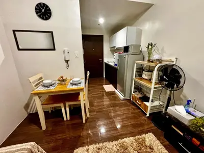 a kitchen with a table and a small kitchen with a refrigerator at Ikigai Delta Makati Condo Luxury Sunset View in Manila
