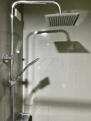 a shower with a glass door with a shower head at Ikigai Delta Makati Condo Luxury Sunset View in Manila