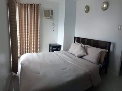 a bedroom with a bed with white sheets and pillows at Explore Manila Trendy 1BR unit in Birch Tower in Manila