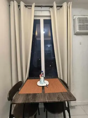 a wooden table and chairs with a table and a window at Explore Manila Trendy 1BR unit in Birch Tower in Manila