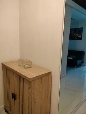 a wooden cabinet in a room with a living room at Explore Manila Trendy 1BR unit in Birch Tower in Manila