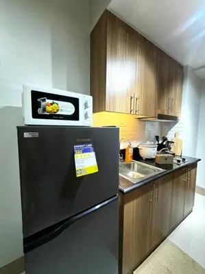 a kitchen with a microwave on top of a refrigerator at Shore 3 katkat staycation in Manila