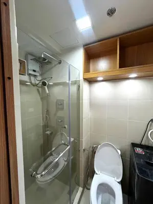 a small bathroom with a toilet and a shower at Shore 3 katkat staycation in Manila