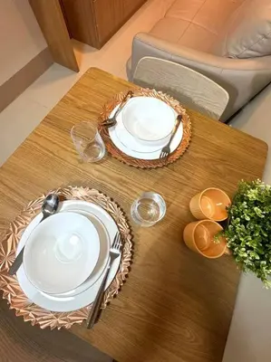a table with two plates and wine glasses on it at Shore 3 katkat staycation in Manila