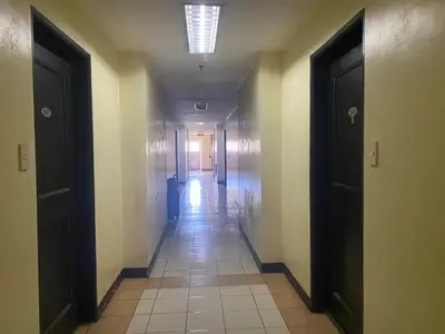 an empty hallway with two doors and a tile floor at Tiaras Luxury Condotel in Manila