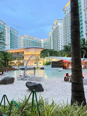a pool at a resort with people in the water at Azure Resort Paranaque deluxe room unit 1601 st tropez tower in Manila