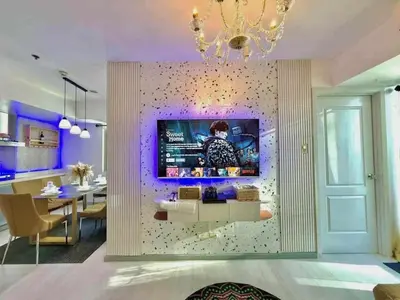 a living room with a tv on a wall at Azure Resort Paranaque deluxe room unit 1601 st tropez tower in Manila