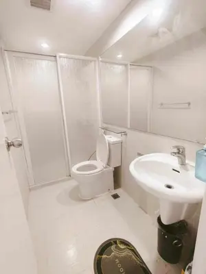 a white bathroom with a toilet and a sink at Azure Resort Paranaque deluxe room unit 1601 st tropez tower in Manila