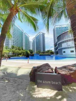 a sign in front of a swimming pool with palm trees at Azure Resort Paranaque deluxe room unit 1601 st tropez tower in Manila