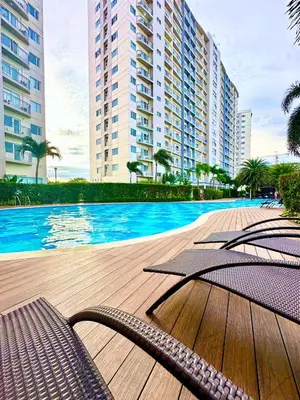 a swimming pool with chairs and buildings in the background at Marias Crib in Manila