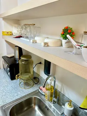 a kitchen with a sink and a counter with dishes at Marias Crib in Manila