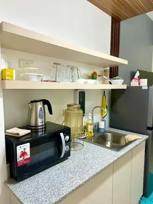 a small kitchen with a microwave and a sink at Marias Crib in Manila