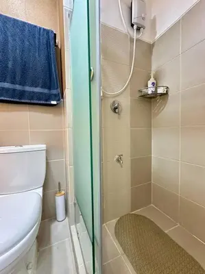 a small bathroom with a toilet and a shower at Marias Crib in Manila