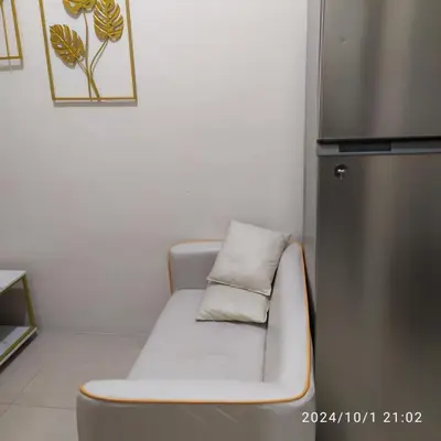 a white couch with a pillow on top of a refrigerator at Staycation by Estelle in Manila