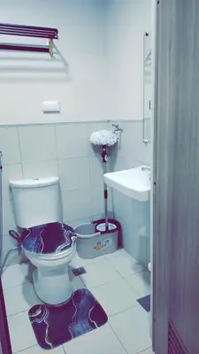 a bathroom with a toilet and a sink at Staycation by Estelle in Manila