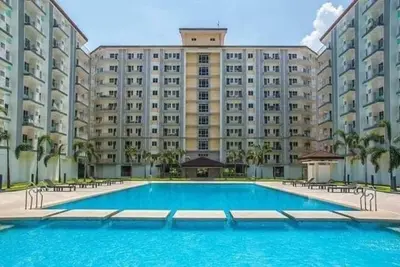 a large apartment building with a large swimming pool at Staycation by Estelle in Manila