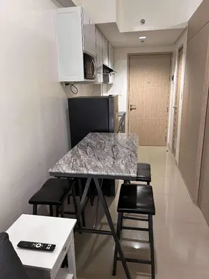 a kitchen with a table and chairs in a room at Newly build Condo Minimalist Charm in Manila