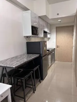 a kitchen with a counter and a table and chairs at Newly build Condo Minimalist Charm in Manila
