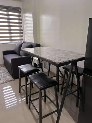 a table and chairs in a living room with a couch at Newly build Condo Minimalist Charm in Manila