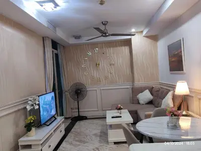 a living room with a couch and a clock on the wall at Condo With Balcony And Bayview In Malate, Manila in Manila