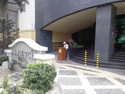 a man standing in front of a building at Condo With Balcony And Bayview In Malate, Manila in Manila