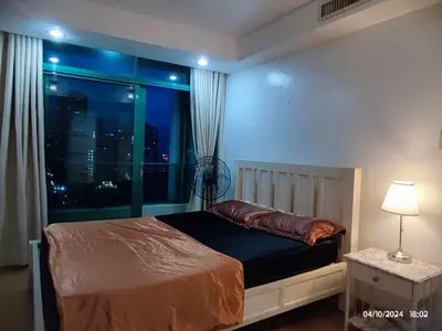 a bedroom with a bed with a view of the city at Condo With Balcony And Bayview In Malate, Manila in Manila