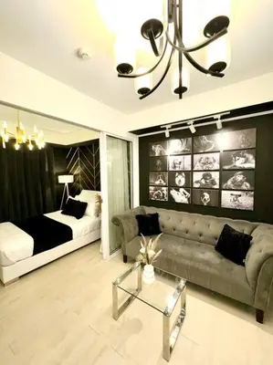a living room with a couch and a bed at Azure 1BR with Projector in Manila