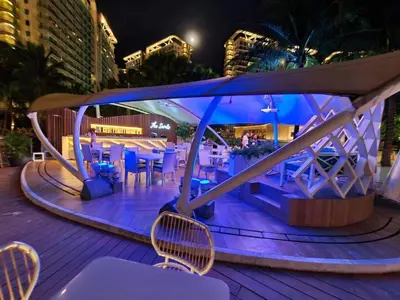 a table and chairs on a deck at night at Azure 1BR with Projector in Manila
