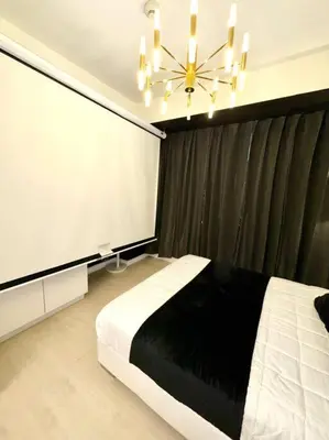 a bedroom with a black and white bed and a chandelier at Azure 1BR with Projector in Manila