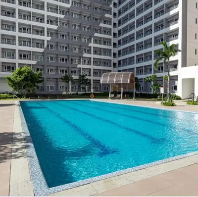 a large swimming pool in front of a large building at Cozy retreat w Balcony, Netflix, 100 mbps internet, Pool, near BGC in Manila