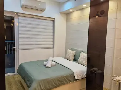 a bed with a teddy bear on it in a room at Cozy retreat w Balcony, Netflix, 100 mbps internet, Pool, near BGC in Manila
