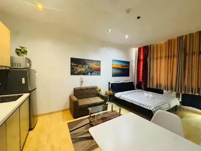 a small living room with a couch and a kitchen at Gramercy Residences Studio with balcony Near Airport in Manila