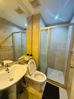 a bathroom with a shower and a toilet and a sink at Gramercy Residences Studio with balcony Near Airport in Manila