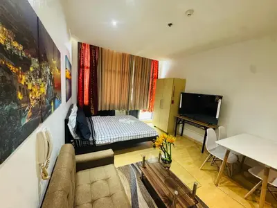 a living room with a couch and a bed at Gramercy Residences Studio with balcony Near Airport in Manila