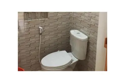 a bathroom with a white toilet in a brick wall at Townhouse OAK Metro Manila Near Osmena Highway PNR Pasay formerly Avitel Hotel in Manila