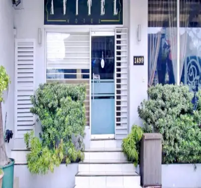 a white house with a blue door and some plants at Townhouse OAK Metro Manila Near Osmena Highway PNR Pasay formerly Avitel Hotel in Manila