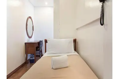 a bedroom with a bed with a mirror on the wall at Townhouse OAK Metro Manila Near Osmena Highway PNR Pasay formerly Avitel Hotel in Manila