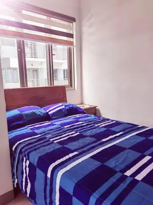 a blue and white bed in a bedroom with a window at 2 Bedroom near MOA S Residences in Manila