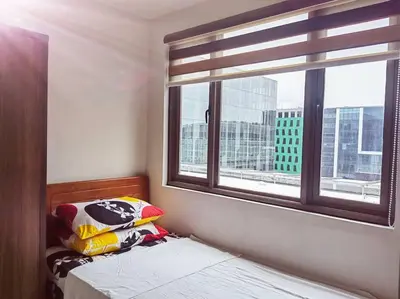 a bedroom with a bed and a window with a view at 2 Bedroom near MOA S Residences in Manila