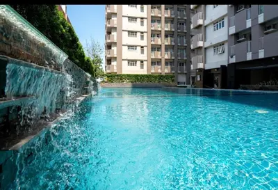 a swimming pool in a building with a water fountain at Affordable & Spacious Condo in Makati in Manila