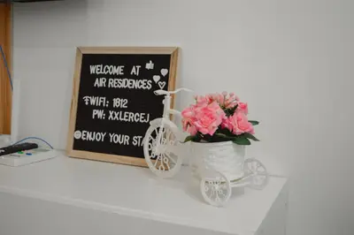 a vase with pink flowers and a bike next to a chalkboard at Air Residences in Manila