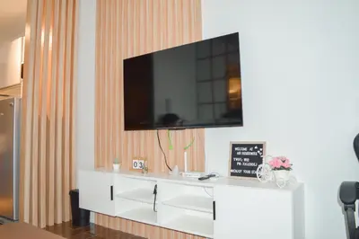 a living room with a white cabinet with a tv on it at Air Residences in Manila
