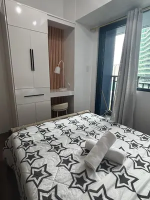 a bedroom with a bed with a black and white comforter at Air Residences in Manila