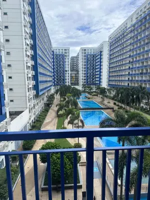 a view of the pool from the balcony of a resort at Sea Residences by Richnell's Staycation 