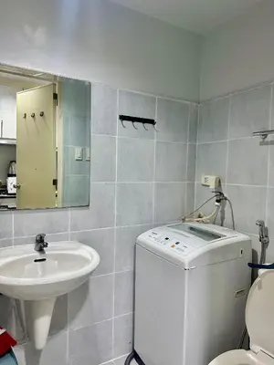 a bathroom with a sink and a washing machine at Sea Residences by Richnell's Staycation 