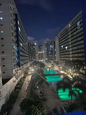 a view of a pool at night with buildings at Sea Residences by Richnell's Staycation 