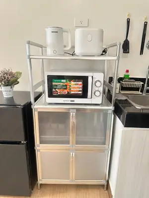 a microwave on a shelf in a kitchen at Enchantress Abode in Trece Martires